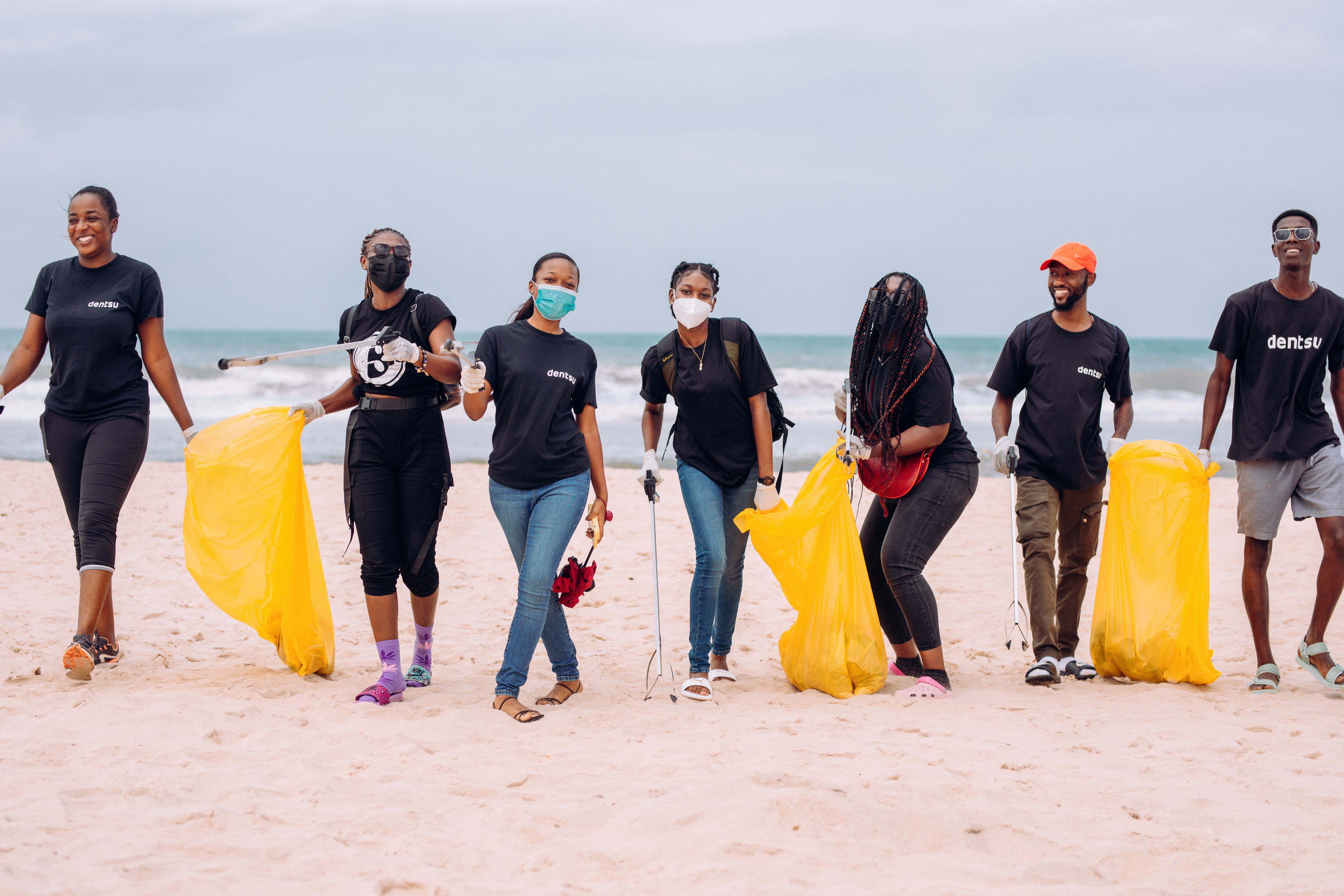 People picking up trash on the beach